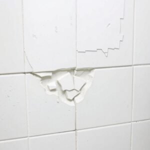 معلم بلاط يقوم بإصلاح بلاط متضرر في حمام بالكويت